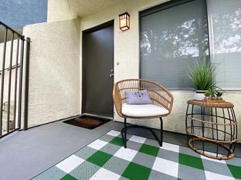 a front porch with a chair and a side table